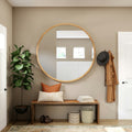Round wall mirror with a warm wood frame